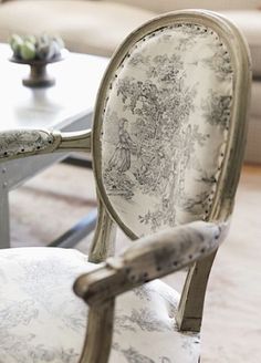 an old chair is upholstered with white fabric and has been painted to look like it's being used as a coffee table