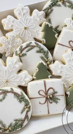 decorated christmas cookies in a white box with green and gold trimmings on them