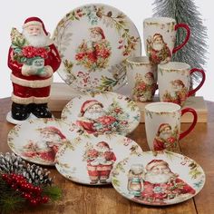 a santa clause figurine sitting on top of a table next to plates and cups