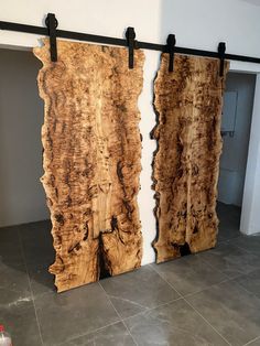 two pieces of wood sitting on top of a floor next to each other in front of a white wall