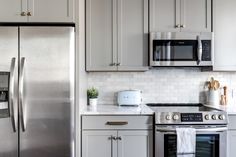 a kitchen with stainless steel appliances and white cabinets