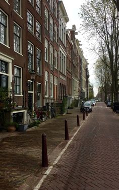 an empty street lined with brick buildings and parked cars