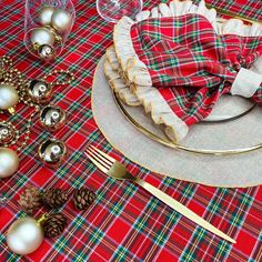 a plaid table cloth with silverware and christmas decorations