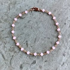 Rose Quartz Bracelet in rose gold fill This dainty circlet features wire-wrapped pink quartz beads. These stones absolute glow! Extra lovely in the rose gold finish - the colors are so complementary. With 14K rose gold-filled clasp components. Boho, graceful, and utterly charming. Also available in ANKLET sizes Rose Pink Quartz - faceted rondelles, approximately 3mm Stones are wrapped in rose gold-plated brass wire Bracelet pictured measures 7 inches in length Fastens with rose gold filled lobst Pink Wire Wrapped Beaded Bracelets With Round Beads, Pink Wire Wrapped Beaded Bracelets As Gift, Pink Wire Wrapped Beaded Bracelets For Gifts, Pink Dainty Bracelet With Adjustable Chain, Dainty Pink Bracelets With Adjustable Chain, Dainty Pink Bracelet With Adjustable Chain, Adjustable Beaded Chain Rosary Bracelet Gift, Handmade Rose Gold Bracelets With Round Beads, Handmade Rose Gold Bracelet With Round Beads