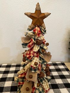 a christmas tree made out of burlocks and plaid fabric with a star on top