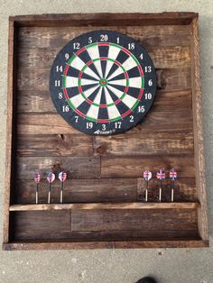 a man standing next to a wooden box with darts in it