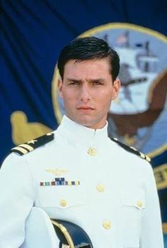 a man in uniform standing next to an american flag