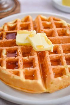 a white plate topped with waffles covered in butter