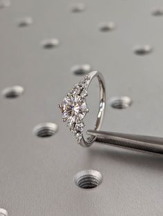 a diamond ring sitting on top of a metal table next to a pair of scissors