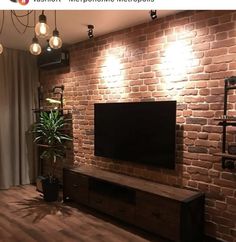 a living room with brick wall and wooden flooring is shown in this instagramtion