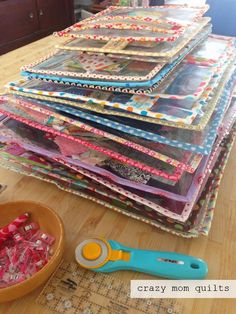 a wooden table topped with lots of different types of crafting supplies and paper pieces