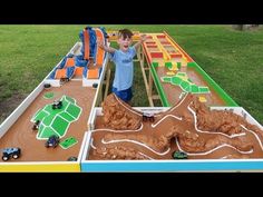 a young boy standing in front of a model train set