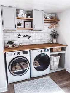 a washer and dryer in a small room with white tile on the walls