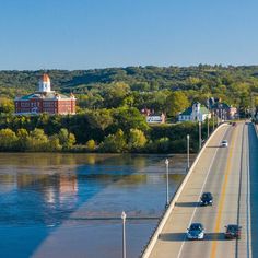 cars are driving on the bridge over the water