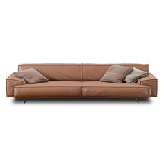 a brown leather couch with two pillows on the back and one pillow in front of it