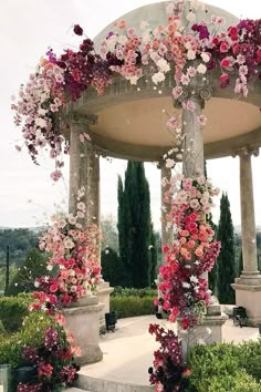 a gazebo covered in lots of pink and white flowers