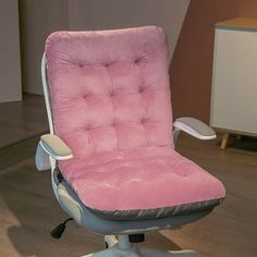 a pink office chair sitting on top of a wooden floor