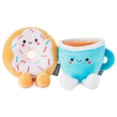 two stuffed toys sitting next to each other near a doughnut and coffee cup with sprinkles