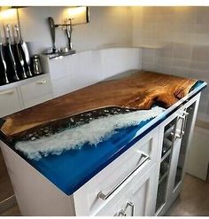 a wooden cutting board on top of a white cabinet