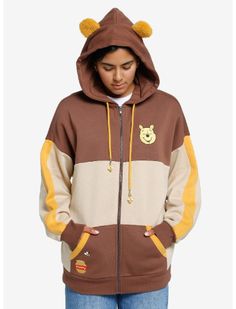 Keep yourself cozy at the Hundred Acre Wood with this Winnie the Pooh hoodie! It features color blocks in warm tones with Pooh embroidered at the chest and a hunny pot at the pocket, plus bees buzzing across the back yoke. The contrast drawstrings have bee charms and the hood has fuzzy 3D Pooh ears! Winnie The Pooh Hoodie, Winnie The Pooh Ears, Hot Topic Sweaters, Hunny Pot, Tall Hoodies, Bee Charms, Plus Size Fits, Lady And The Tramp, Disney Winnie The Pooh