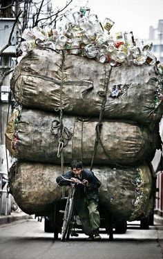 a man on a bike next to a large pile of bottles