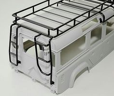 a white truck with metal bars on the top and bottom bunks, is shown