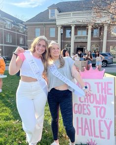 two women standing next to each other in front of a sign that says the crown goes to haley