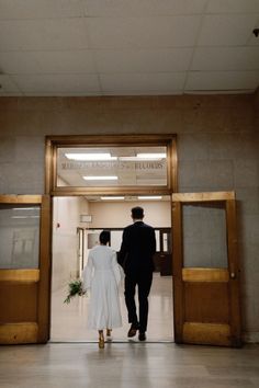 a man and woman are walking into an office building