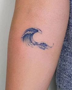 a woman's arm with a wave tattoo on it