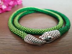 Handmade snake necklace in green glass seed beads. This is a particularly adorable piece of jewelry for a birthday, Christmas or Mother's Day gift.  With these snake necklaces you will certainly not go unnoticed! Length with clasp about: 20 inches (51 cm) Thickness about 0.31 inches (0.8 cm) The color of the photos may vary slightly depending on the monitor settings. Washing is not recommended. Handmade with Love! Green Tiny Beads Jewelry For Crafting, Green Beaded Necklace With Lobster Clasp As Gift, Handmade Snake-shaped Beaded Necklace For Gift, Green Round Beaded Nickel-free Necklace, Green Nickel-free Round Beaded Necklace, Adjustable Nickel Free Green Beaded Necklace, Green Snake Necklace, Serpent Necklace, Purple Snake