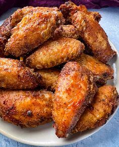 fried chicken wings on a white plate with purple towel in the backgroung