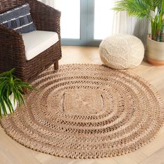 a living room with wicker furniture and large potted plant on the floor next to it