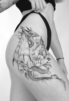 a woman with a dragon tattoo on her thigh