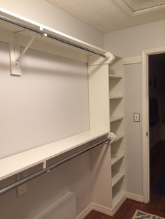 an empty closet with white shelves and doors