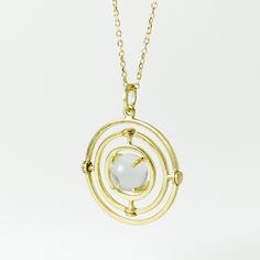 "This listing is for an 18k yellow gold and rock crystal quartz kinetic pendant, with rotating sphere and orbital circles, inspired by pools of light jewelry of the Victorian Era. I hand-fabricate these pendants, start to finish, from gold wire. Three concentric circles rotate around and within each other on two different axes. The inner most circle holds a 7mm natural, undrilled quartz sphere in four dual-sided prongs. The frame has been brought to a high shine. In the Victorian Era, it was bel Modern Jewelry With Rotating Bezel For Gift, Modern Gold Orb Jewelry, Inverted Image, Kinetic Pendant, Moon Door, Kinetic Jewelry, Art Nouveau Necklaces, Light Jewelry, Concentric Circles