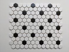 a white and black tiled wall with hexagonal tiles on it's sides