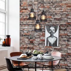 a dining room with brick walls and chairs around a round table in front of an art piece