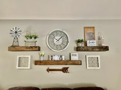 a living room filled with furniture and decor on top of a wooden shelf next to a wall mounted clock