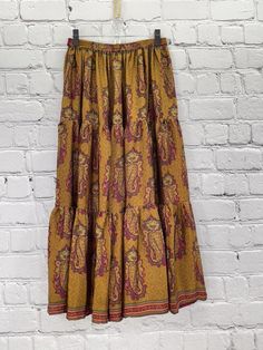 Twirl the day away in this gorgeous, buttery soft skirt. The long, full design is flattering to every shape. Made of vintage rasgulla silk saris. Each piece will be unique. Available in 2 sizes S/M 4-10 L/XL 12-18 Approximately 38” long Care Instructions: Hand wash and line dry for longest life. Disclaimer: The material used in this style is repurposed, vintage material. Small imperfections may be present. Fabrics may have small threads or holes in the layers. Small stains may be found. Bohemian Maxi Skirt For Festive Occasions, Bohemian Tiered Skirt For Festive Occasions, Traditional Long Skirt With Boho Print, Bohemian Long Maxi Skirt With Paisley Print, Bohemian Flowy Paisley Print Skirt, Bohemian Lined Skirt For Festive Occasions, Bohemian Festive Lined Skirt, Bohemian Paisley Print Skirt, Festive Bohemian Lined Skirt