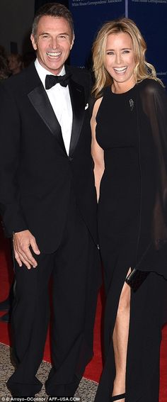 a man and woman in formal wear posing for the camera on a red carpeted area