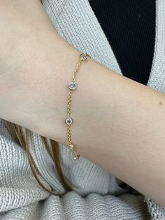 Bring a touch of elegance to your looks with this classic Diamonds by the Yard bracelet.  Featuring five round diamonds set in bezels on a delicate 14K gold Rolo chain, this piece is effortlessly chic. Material: 14K Yellow Gold Diamonds: Round Cut, Bezel Set *These are 100% naturally Earth-Mined Diamonds. Color: G Clarity: VS2 Length: 6.5Inches Elegant Diamond Bracelet With Bezel Setting, Elegant Diamond Gold Bracelet With Bezel Setting, Elegant Gold Bracelet With Diamond Bezel Setting, Elegant Diamond Bracelet With Bezel Setting For Anniversary, Elegant Yellow Gold Tennis Bracelet With Bezel Setting, Elegant Anniversary Diamond Bracelet With Bezel Setting, Delicate Gold Diamond Tennis Bracelet, Dainty Diamond Bracelet With Round Cut Accents, Dainty Yellow Gold Tennis Bracelet With Diamond Accents