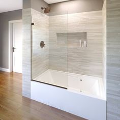 a bathroom with a glass shower door and wooden floors