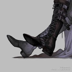 a pair of black boots sitting next to each other on top of a gray floor