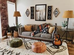 a living room filled with lots of furniture next to a wall mounted pictures and floor lamps