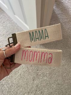 someone is holding up two name tags that say mama and noma in pink letters