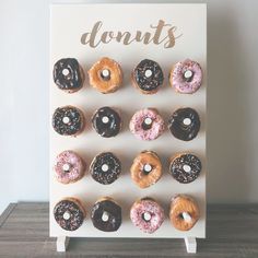 a white sign with donuts on it that says donuts in front of them