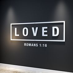 a black wall with the words loved and romans written in white letters on it