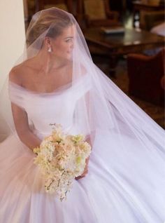 a woman in a wedding dress holding a bouquet