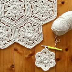 the crocheted doily is laying on the floor next to yarn and scissors