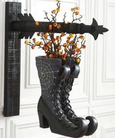 a pair of black boots with flowers in them hanging from a hook on a door